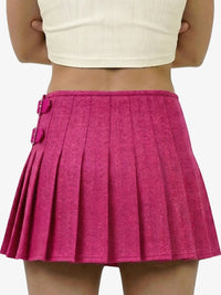 Pink pleated skirt worn by a person on a white background