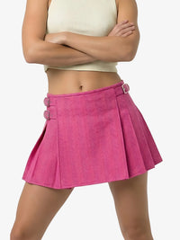 Person wearing a pink pleated skirt on a white background