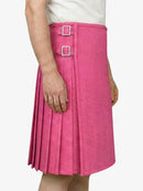 Person wearing a pink pleated skirt with silver buckles on a white background