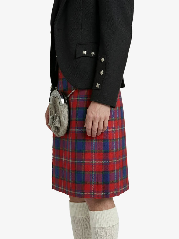 Person wearing a black blazer and red plaid kilt on a white background