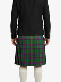 Person wearing a black jacket and green plaid kilt on a white background