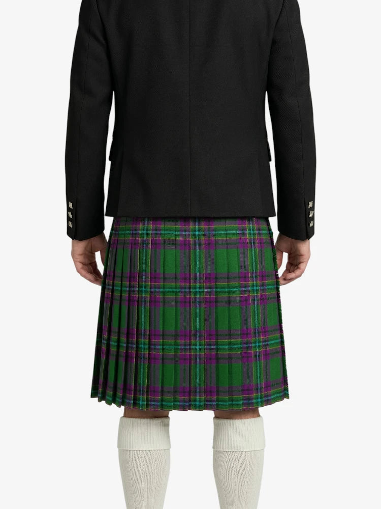 Person wearing a black jacket and green plaid kilt on a white background