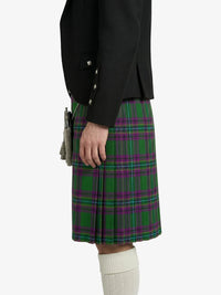 Person wearing a black jacket and green plaid kilt on a white background