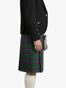 Person wearing a black jacket and green plaid kilt on a white background