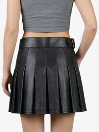 Black pleated leather skirt worn by a person on a white background