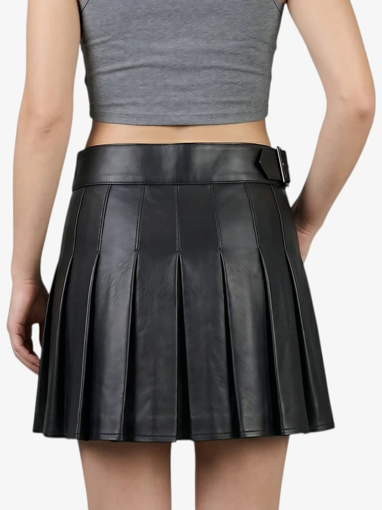 Black pleated leather skirt worn by a person on a white background
