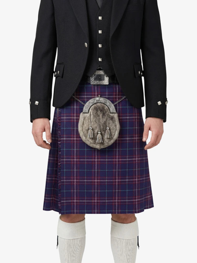 Person wearing a traditional Scottish kilt with a tartan pattern on a white background