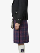 Person wearing a black blazer and plaid kilt on a white background