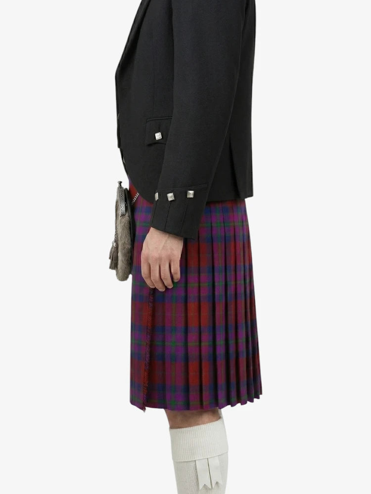 Person wearing a black blazer and red plaid kilt on a white background