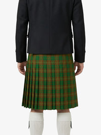 Person wearing a black jacket and green plaid kilt on a white background