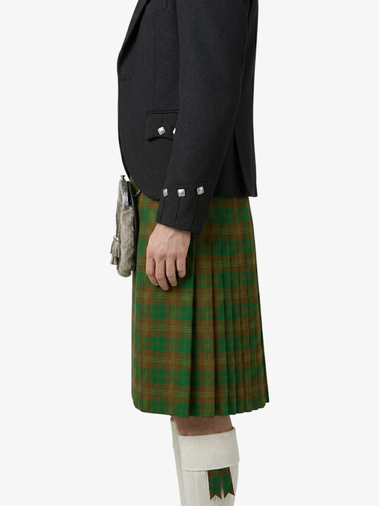 Person wearing a dark jacket and green plaid kilt on a white background