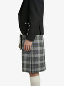 Person wearing a black jacket and plaid kilt on a white background