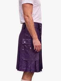 A person wearing a purple pleated leather kilt with side cargo pockets and silver snap buttons, paired with a white t-shirt, shown from the side against a light gray background.