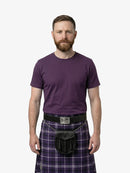 Man wearing a purple t-shirt and tartan kilt on a white background