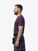 Man wearing a purple t-shirt and plaid kilt on a white background