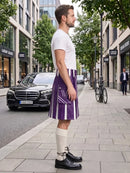 A man stands on a city sidewalk wearing a purple and white striped kilt, a white t-shirt, cream-colored knee-high socks, and black leather shoes. A black Mercedes-Benz is parked on the street behind him, with trees and storefronts in the background.
