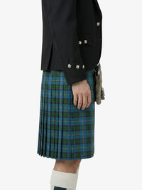 Person wearing a black jacket with silver buttons and a green plaid kilt on a white background