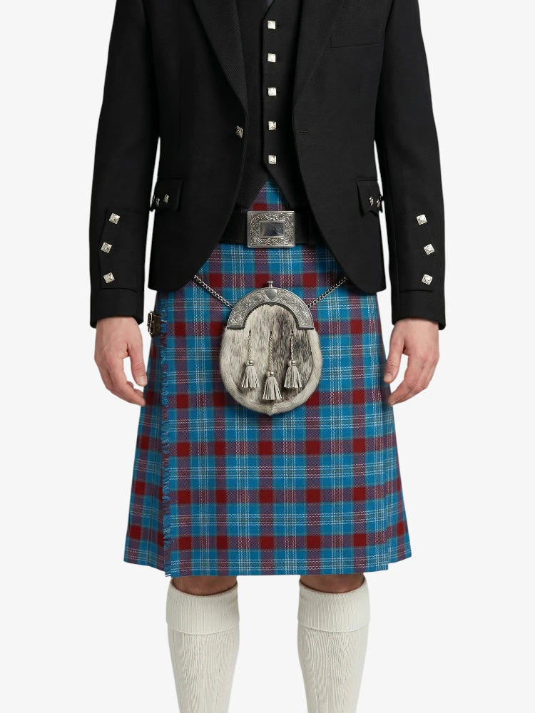 Person wearing a black jacket and blue plaid kilt with a silver sporran on a white background