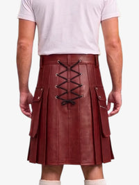 A person shown from the back wearing a dark red faux-leather pleated kilt with a black lace-up closure and side pockets, paired with a light pink t-shirt and white socks against a white background.