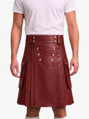 A person wearing a dark reddish-brown faux leather kilt with silver-tone metal buttons and flap pockets, paired with a white t-shirt against a plain white background.
