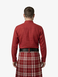 Man wearing a red shirt and plaid kilt on a white background