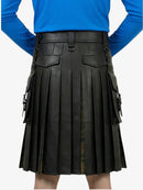 Black pleated kilt worn by a person with a blue top on a white background