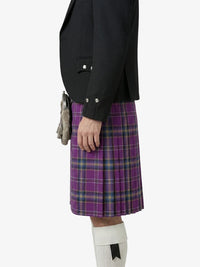 Person wearing a black jacket and purple plaid kilt on a white background