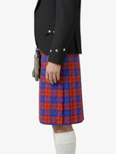 Person wearing a black jacket and red and blue plaid kilt on a white background