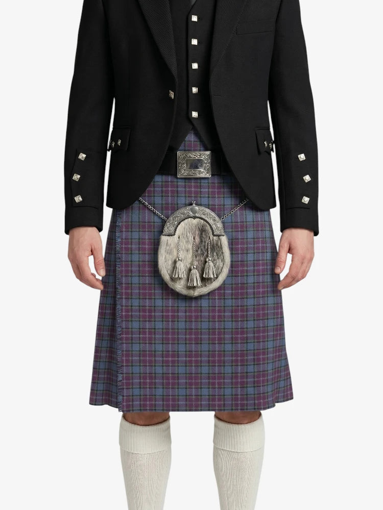 Person wearing a traditional Scottish kilt with a jacket on a white background