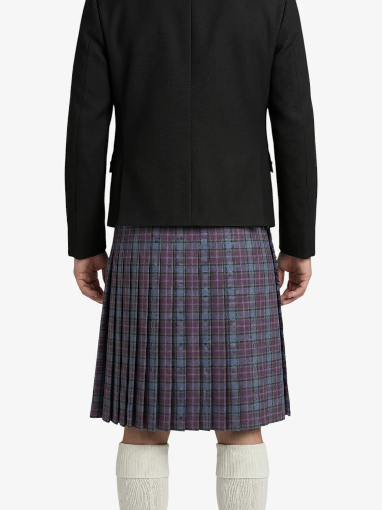 Person wearing a black jacket and plaid kilt on a white background
