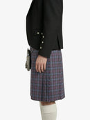 Person wearing a black jacket and plaid kilt on a white background