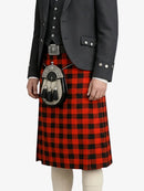 Person wearing a traditional Scottish kilt with a black jacket on a white background