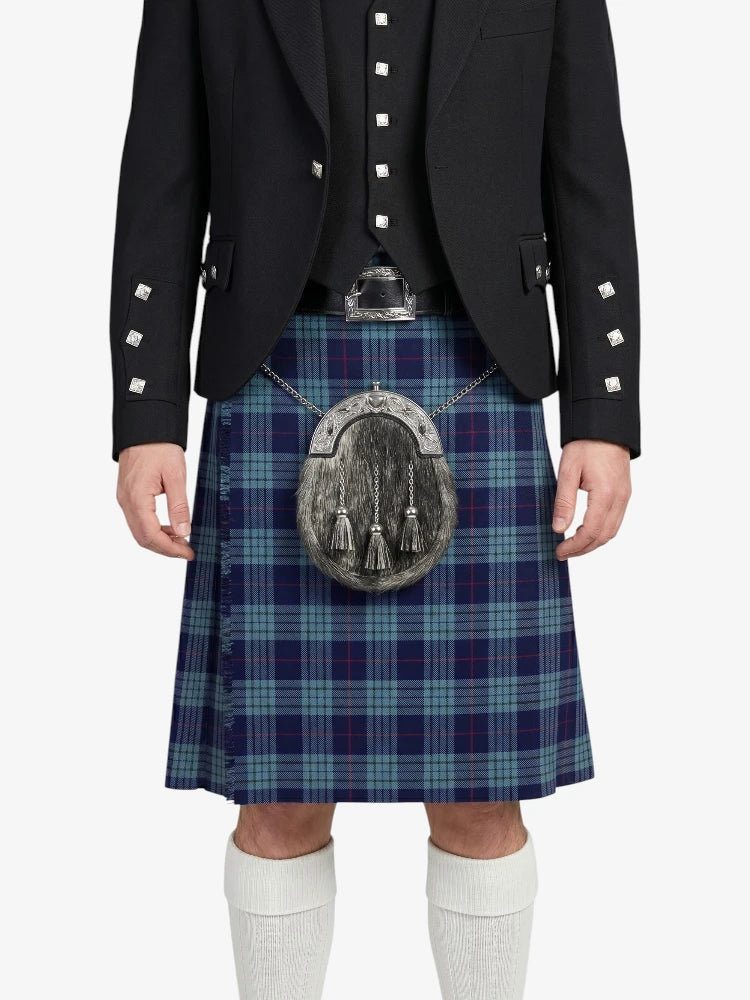 Person wearing a black jacket, blue plaid kilt, and white socks on a white background