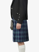 Person wearing a dark jacket and blue plaid kilt on a white background