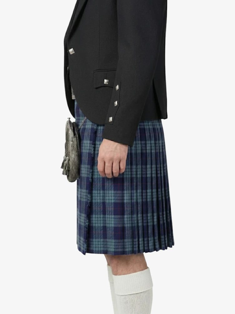 Person wearing a dark jacket and blue plaid kilt on a white background