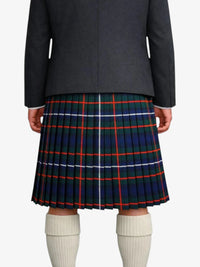 Person wearing a black jacket and a plaid kilt with white socks on a white background
