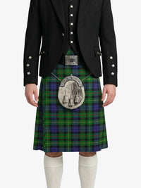 Person wearing a traditional Scottish kilt with a tartan pattern on a white background