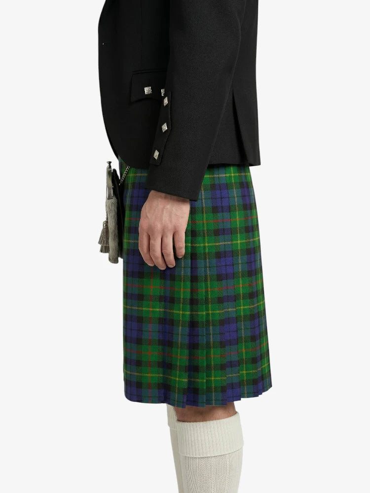 Person wearing a black jacket and green plaid kilt on a white background