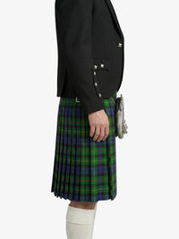 Person wearing a black blazer and green plaid kilt on a white background