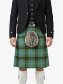 Person wearing a traditional Scottish kilt with a jacket and white socks on a white background