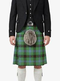 Person wearing a traditional Scottish kilt with a jacket and white socks on a white background