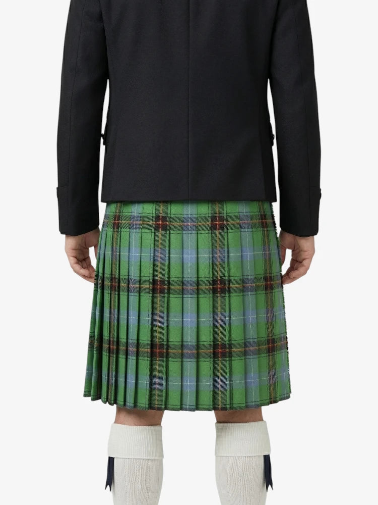 Person wearing a black jacket and green plaid kilt on a white background