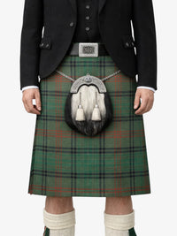 Person wearing a traditional Scottish kilt with a sporran on a white background
