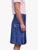 A person wearing a blue pleated leather kilt with silver-tone hardware and a white t-shirt, shown from the side against a light gray background.