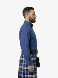 Man wearing a blue shirt and plaid kilt on a white background