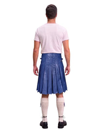 A man shown from the back wearing a blue leather kilt, a light pink t-shirt, cream-colored knee-high socks, and black shoes, isolated on a white background.