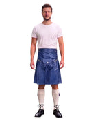 A man modeling a blue leather kilt with a matching belt and silver buckle, paired with a white t-shirt, white knee-high socks, and black lace-up boots, against a solid white background.