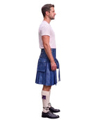 A man shown in profile wearing a blue leather kilt, a white t-shirt, white knee-high socks, and black leather shoes, against a plain white background.