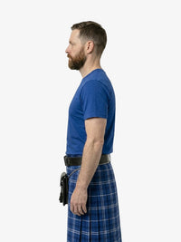 Man wearing a blue t-shirt and plaid kilt on a white background