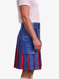 A person wearing a blue pleated leather kilt with red vertical stripe accents and silver hardware, paired with a white t-shirt, shown from the side against a light gray background.